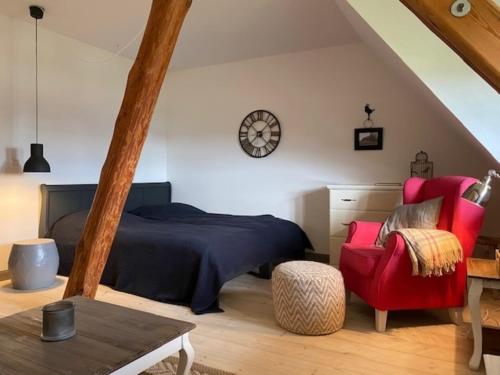 una camera da letto con un letto e una sedia rossa di Gut Alt Farpen Ferienwohnung 4 a Blowatz