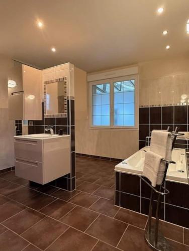 La grande salle de bains est pourvue d'un lavabo et d'une baignoire. dans l'établissement Piscine chauffée-Beauval et Châteaux-, à Cormeray