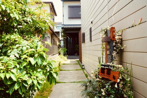 a narrow alley with plants and a building at 遥華-Haruka House in Kyoto