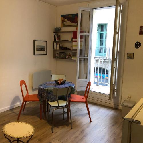 une salle à manger avec une table et des chaises et une fenêtre dans l'établissement Joli petit appartement dans le quartier haut, à Sète
