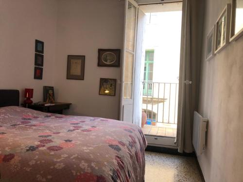- une chambre avec un lit et une porte donnant sur un balcon dans l'établissement Joli petit appartement dans le quartier haut, à Sète