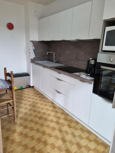 une cuisine avec des armoires blanches et un évier dans l'établissement Sete T3 sur les quais en centre ville parking, à Sète