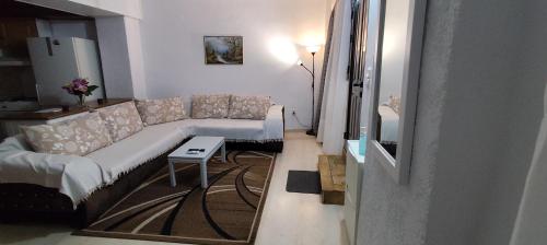 a living room with a couch and a table at Ευρύχωρο και άνετο διαμέρισμα στην Ιτέα Joanna's Apartment in Kírra