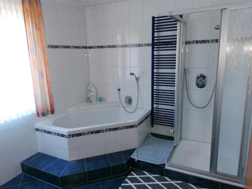 a bathroom with a tub and a shower at Ferienwohnung Gebken in Börgerwald