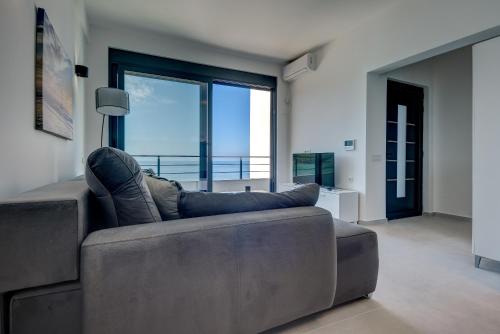 a person laying on a couch in a living room at Sea Breeze Apartment in Kruče