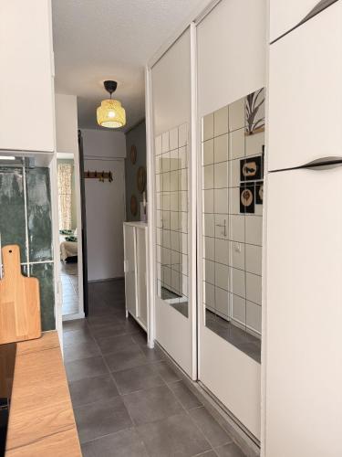 un couloir avec des portes coulissantes en verre dans une maison dans l'établissement Sete Appartement face a la mer et au port de plaisance, à Sète