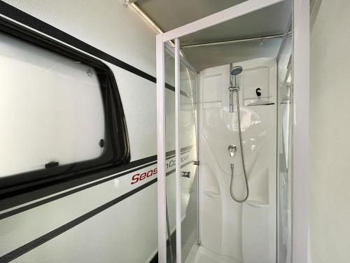 a bathroom with a shower with a glass door at Mietwohnwagen 02 in Heringsdorf