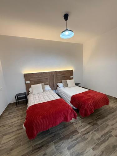 two beds with red and white sheets in a room at Casa De la Vega in Cenes de la Vega