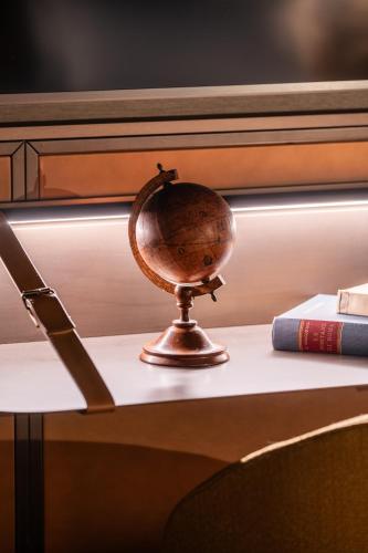 a small globe sitting on a table next to a book at The Goethe Hotel - Small Luxury Hotels of the World in Rome