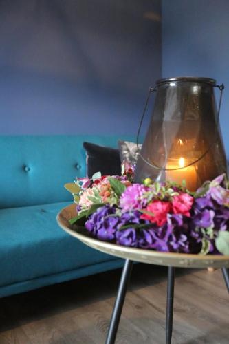 a table with a bouquet of flowers and a candle at BLUMENSTIL Ferienwohnungen 3 in Bad Salzungen