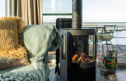 a fireplace in a living room with a fire at Hausboot Paradise in Klitten