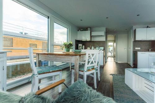 a kitchen with a table and two chairs and a counter at Hausboot Paradise in Klitten