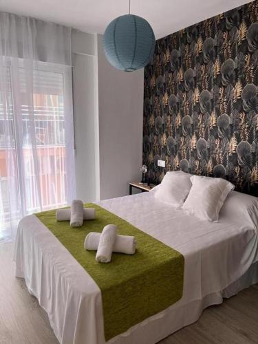 a bedroom with a large bed with towels on it at Chloe Apartments TRG in Benidorm