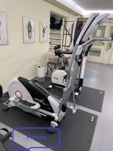 a gym with a treadmill and a elliptical machine at FeWo J 24 in Laboe