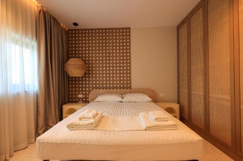 a bedroom with a bed with towels on it at SanPietro Premium Villas in Draçi