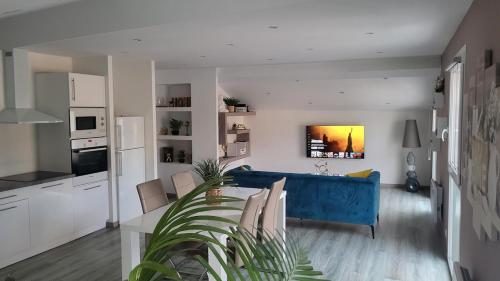 un salon avec un canapé bleu et une cuisine dans l'établissement Charmant T4 entre terre et mer, à Bages