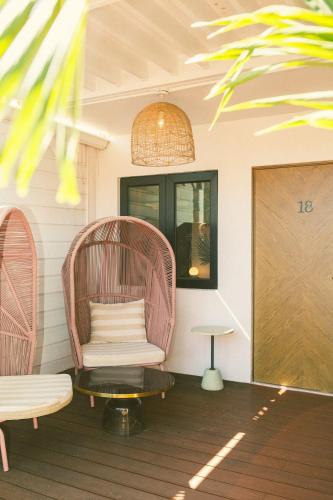 a room with a wicker chair and a table at The Pink Palm Hotel - Adults Only in Charlotte Amalie