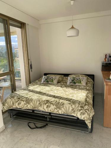 une chambre avec un lit dans une pièce avec une fenêtre dans l'établissement Appartement T2 Residence front de mer, à Mandelieu-la-Napoule