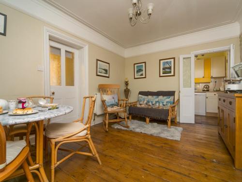a kitchen and dining room with a table and chairs at Tyn Lon, Moelfre, A Traditional Welsh Home By The Coast Pass the Keys in Moelfre