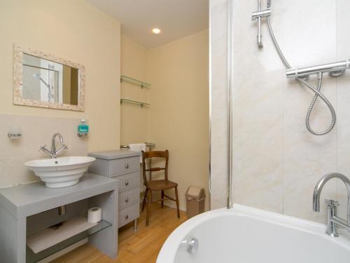a bathroom with a white tub and a sink at Tyn Lon, Moelfre, A Traditional Welsh Home By The Coast Pass the Keys in Moelfre
