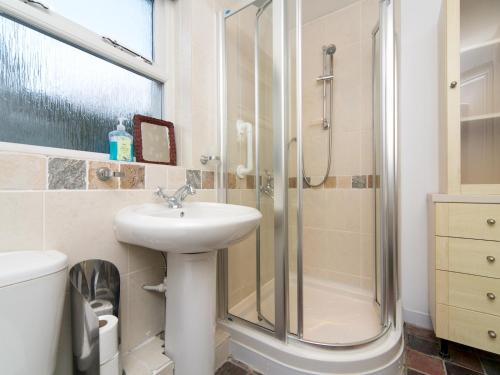 a bathroom with a sink and a shower at Tyn Lon, Moelfre, A Traditional Welsh Home By The Coast Pass the Keys in Moelfre