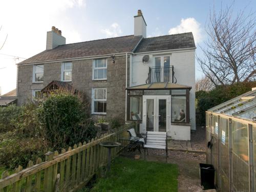 a house with a fence in front of it at Tyn Lon, Moelfre, A Traditional Welsh Home By The Coast Pass the Keys in Moelfre