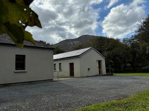 a white building with a mountain in the background at Apartment 473 - Kylemore in Kylemore