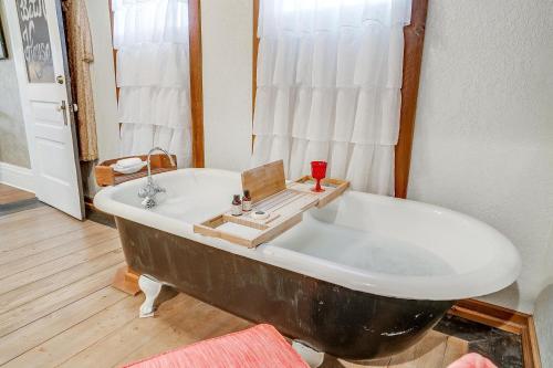 an old bath tub in a room with a window at The Gallery House Boutique Hotel in Stephenville