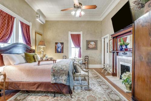 a bedroom with a bed and a fireplace at The Gallery House Boutique Hotel in Stephenville