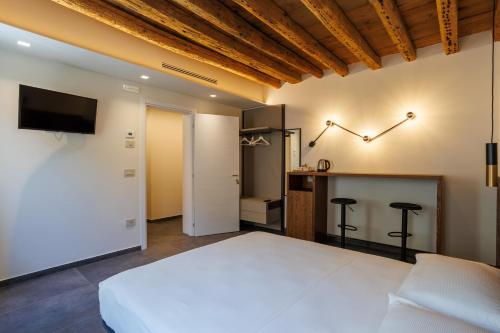 a bedroom with a large white bed and a bar at 1823 Room in Chioggia