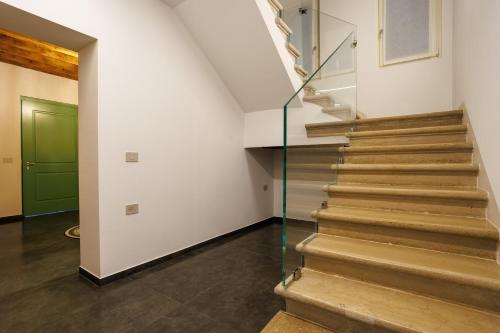 a glass staircase in a house with a green door at 1823 Room in Chioggia