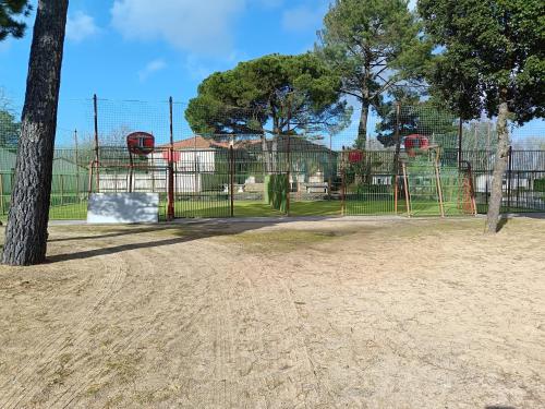 a park with a playground with a tree at MH F52 Camping Bois Masson in Saint-Jean-de-Monts