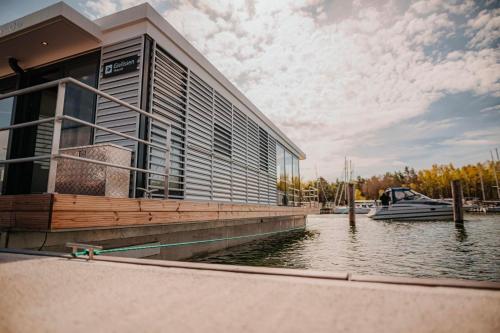 a large building with a boat in the water at Hausboot Trinity - LP5 in Peenemünde