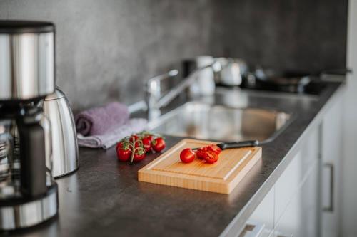 a kitchen counter with a cutting board with tomatoes on it at Hausboot Trinity - LP5 in Peenemünde