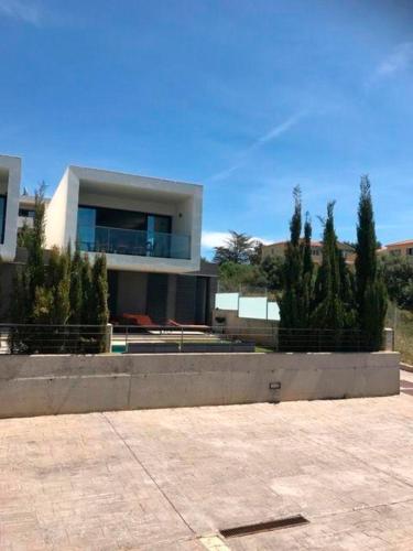 a large white house with trees in front of it at Luxus Chalet Casas blancas in Cala Mendia