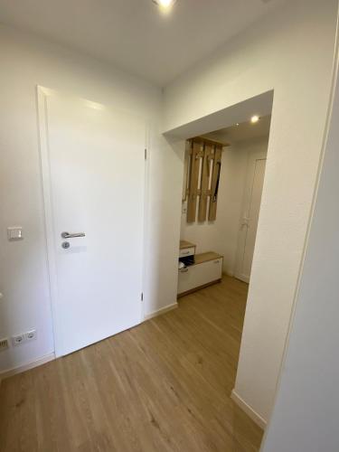 an empty room with a white door and wooden floors at Alte Molkerei FeWo 1 in Zilly