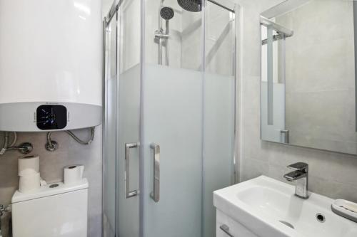 une salle de bain blanche avec une douche et un lavabo dans l'établissement 513 Suite Marie - Superbe logement Quartier Marais, à Paris