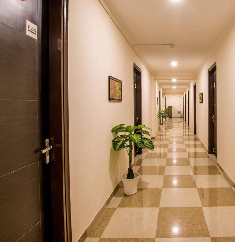 a hallway with a tile floor and a potted plant at Heistel Gurugram in Gurgaon