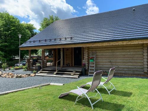 two chairs sitting in the grass in front of a cabin at Hahnenkleer Hütte Harzliebe in Goslar