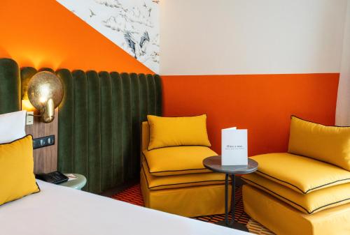 a room with two chairs and a bed and a table at Mercure Shéhérazade Rabat in Rabat