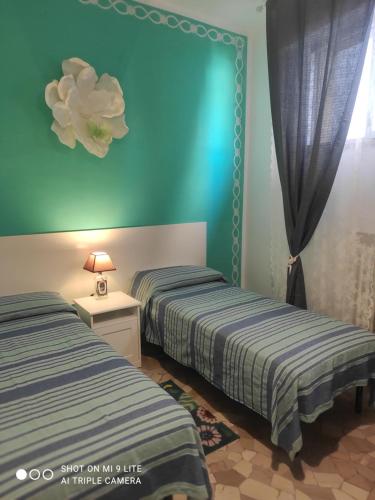 two beds in a room with blue walls at Casa di Ana 2 in Ancona