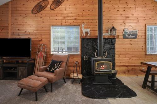 a living room with a fireplace and a tv at Basecamp in La Pine