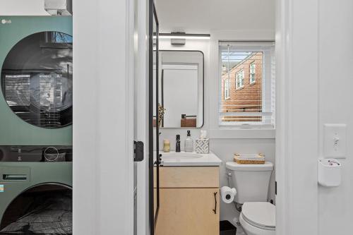 a bathroom with a sink and a toilet and a mirror at The Acorn - Tiny House in HISTORIC OAKWOOD in Raleigh