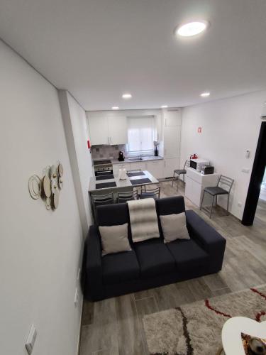 a living room with a couch and a kitchen at Casa de São Miguel in Mirandela