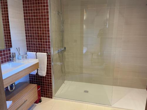 a bathroom with a glass shower and a sink at Les Flors - Hotel Rural & Cabanyes in Gramós