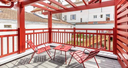a patio with two chairs and a table on a balcony at Hôtel Kemaris in Biarritz