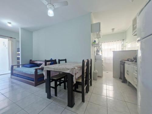 eine Küche und ein Esszimmer mit einem Tisch und einem Bett in der Unterkunft Apartamento completo Condomínio Caribe Ubatuba in Ubatuba