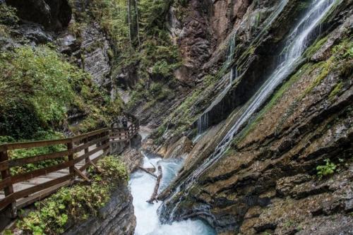 a bridge over a waterfall next to a river at Alpenschwänchen 2 - Salzschwänchen in Bad Reichenhall