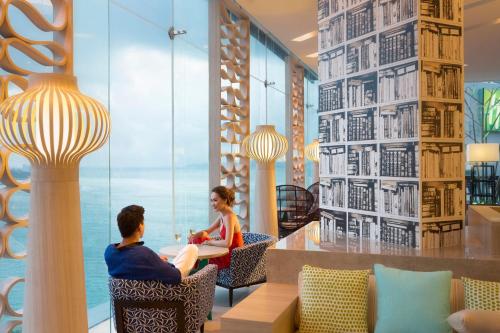 a man and woman sitting in chairs in a lobby at Holiday Inn Pattaya by IHG in Pattaya Central