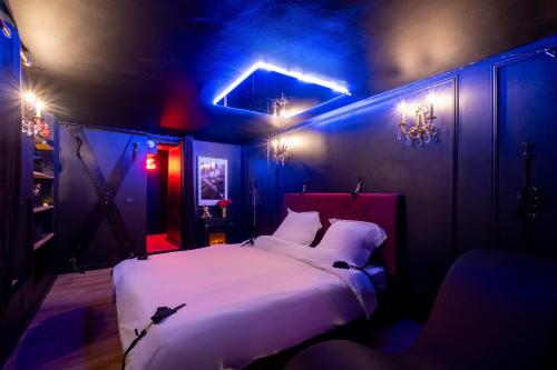 una camera da letto con un letto bianco e illuminazione blu di Le Boudoir Secret - Love Room avec Chambre Secrète a Le Luc